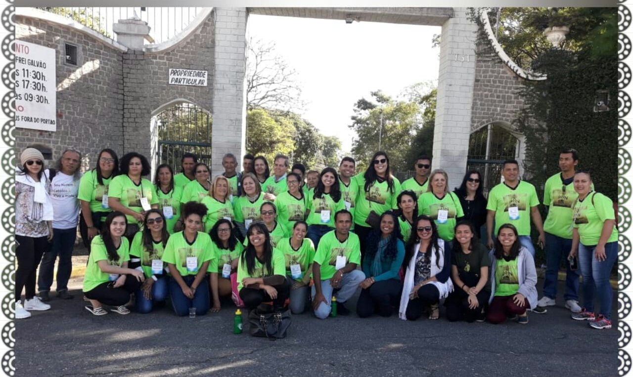 Grupo da Caravana Pai & Filho, com camisetas verde-limão, reunido no portão de entrada da Canção Nova