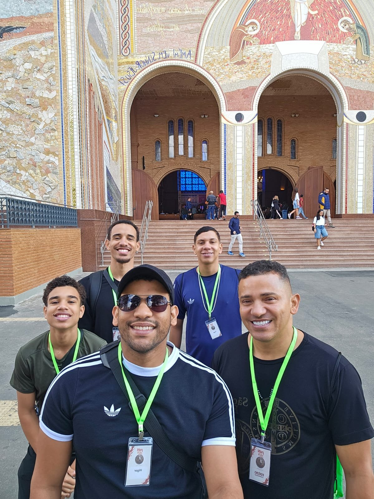Grupo de jovens em frente à fachada em mosaico da Basílica, antes da celebração